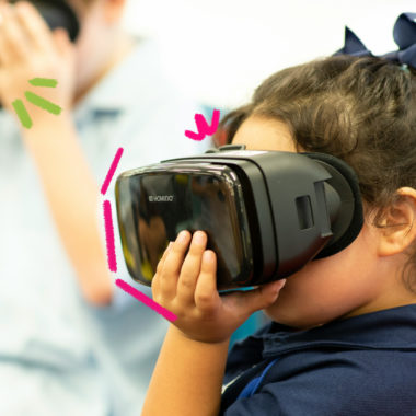 Uma menina e um menino em segundo plano usam óculos de realidade virtual