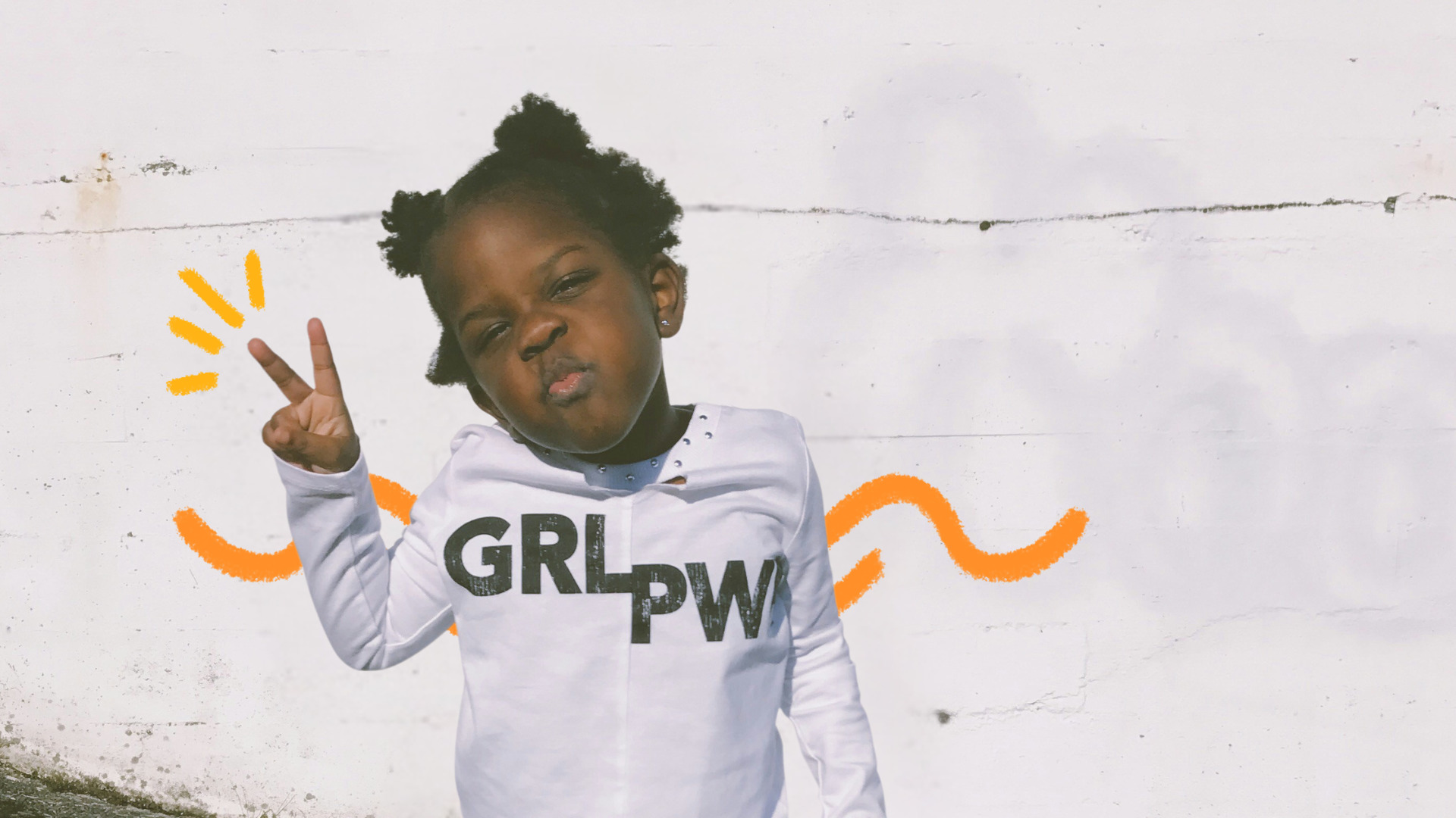 Meninas brincam menos: Imagem mostra uma menina negra, de cabelos crespos amarrados, vestido um moleton branco.