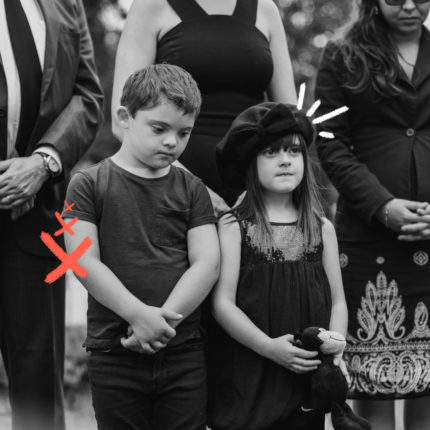 Imagem em preto e branco mostra duas crianças tristes, em um velório, rementendo ao luto infantil.