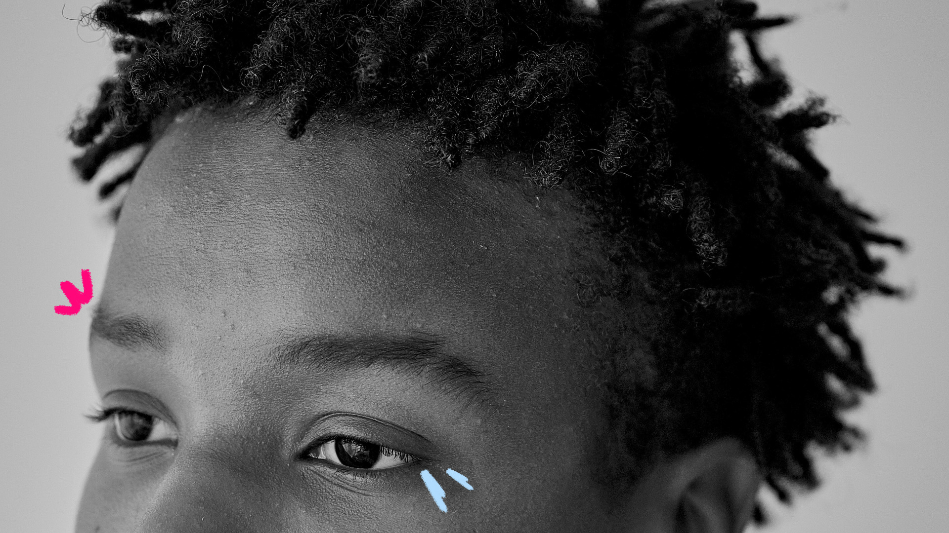 Imagem de capa para matéria sobre racismo na escola mostra a metade do rosto de um menino negro e riscos coloridos perto dos olhos.