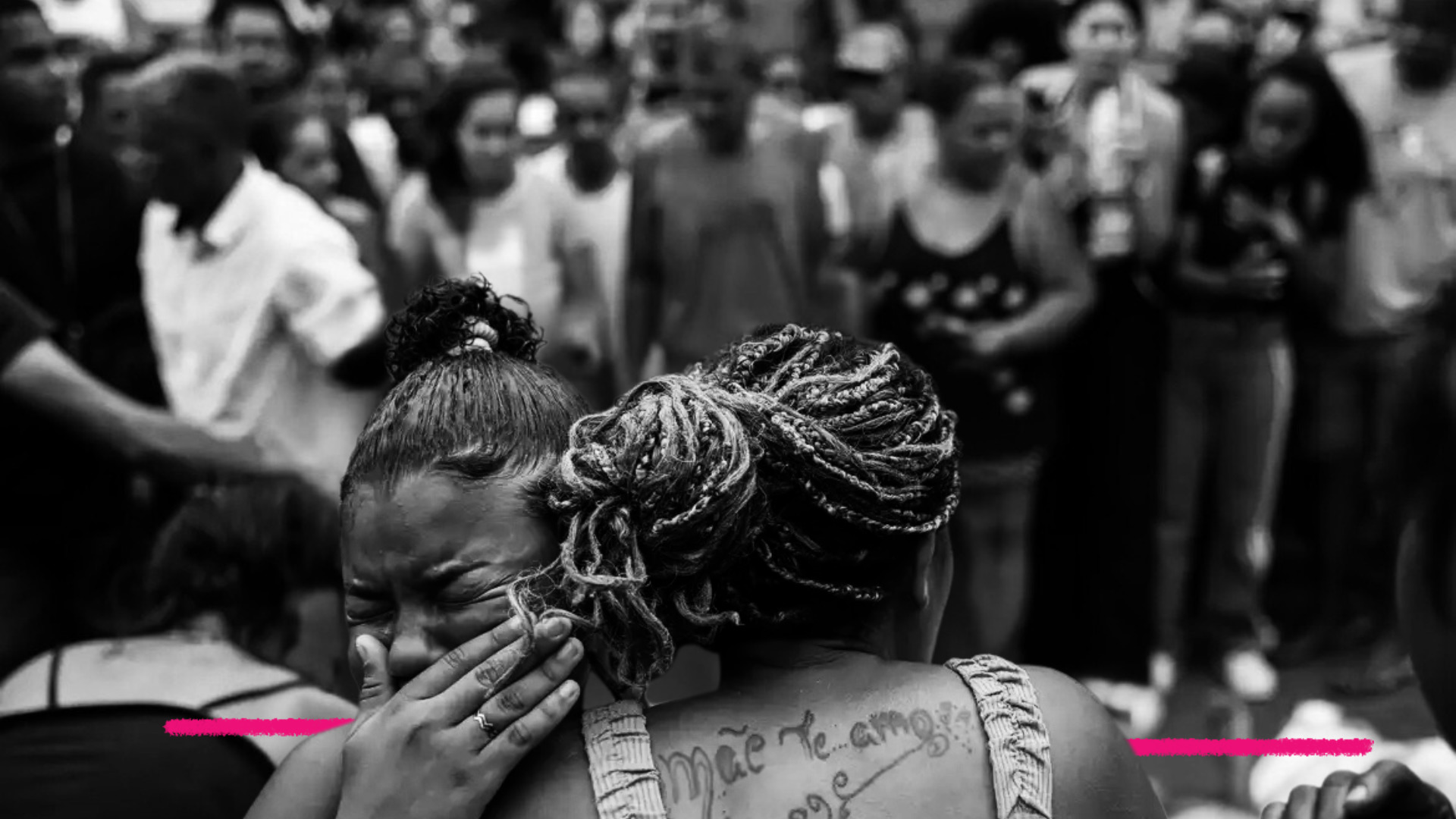 Foto em preto e branco mostra duas mulheres se abraçando. A matéria fala de segurança pública para as crianças da favela depois da mais recente operação policial no Rio de Janeiro.
