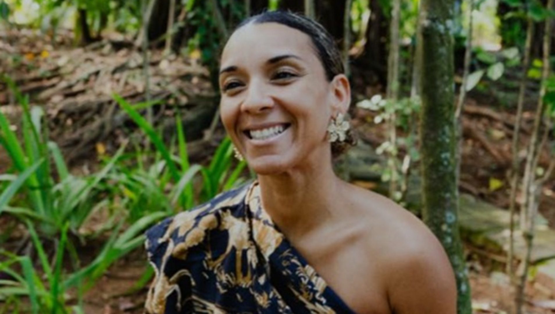 Imagem mostra foto de Silvane Vasconcelos, uma mulher negra. Ela está com cabelos presos, vestido de um ombro só florido e sorri para a foto. Ela fala sobre a importância da representatividade.