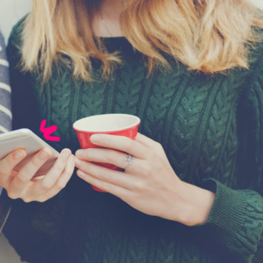 Imagem mostra apenas as mãos de uma adolescente segurando uma xícara e um celular. Ela ilustra uma reportagem sobre redes sociais e infância