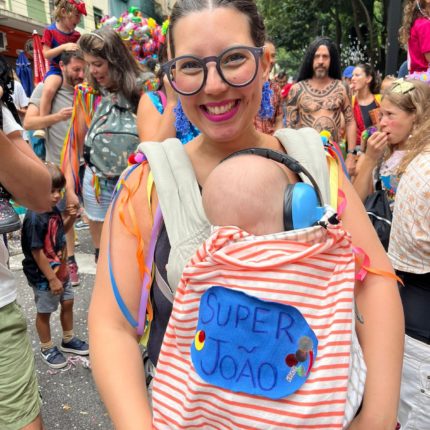 Mulher com bebê no colo no carnaval de São Paulo