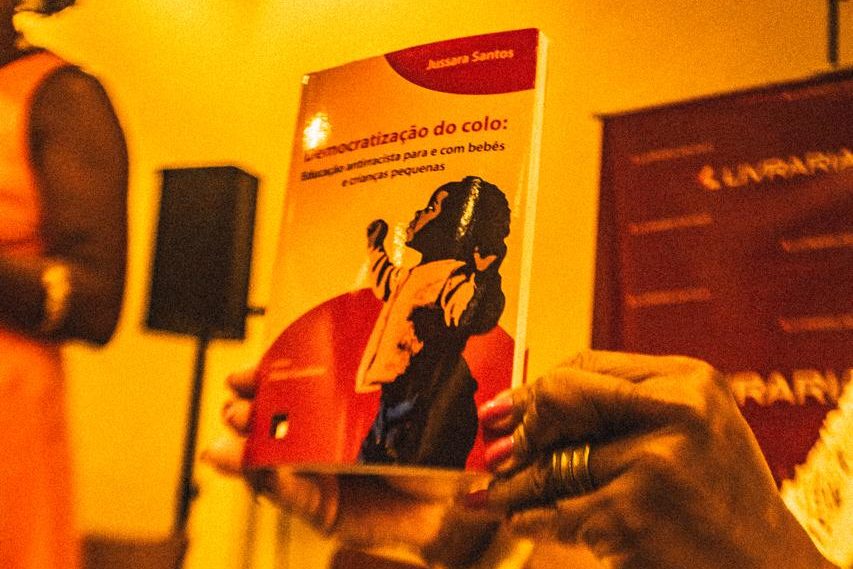Livro “Democratização do colo”, que aborda as relações raciais e o cuidado de bebês e crianças pequenas.
